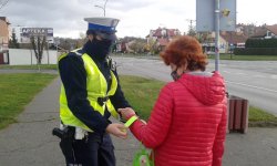 policjanta ruchu drogowego zakłada odblask na rękę kobiety