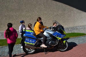 9. dziewczynka w żółtej kurtce siedzi na służbowym motocyklu, obok inne dzieci