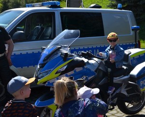 5. chłopiec na policyjnym motocyklu, w ręku trzyma puszkę na datki na leczenie małej Wiktorii