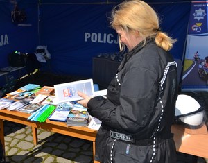 6. kobieta trzyma w ręce ulotkę z informacjami o rekrutacji do służby w Policji
