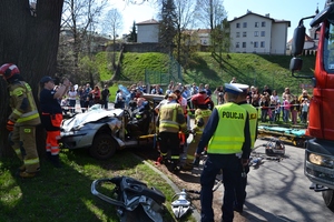 14. pokaz usuwania skutków wypadku - rozbity samochód, strażacy, policjanci, ratownicy medyczni, w tle uczestnicy pikniku