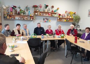 policjant i seniorki siedzące przy stole