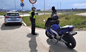 kontrola drogowa - policjant i motocyklista stojący przy swoim jednośladzie