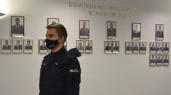 nowy policjant, w tle galeria Komendantów Miejskich Policji w Nowym Sączu