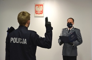 nowy policjant wypowiada słowa ślubowania, obok Komendant