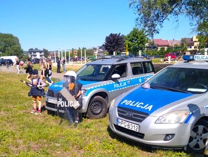 dzieci ze sprzętem policyjnym przy radiowozach