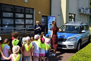 policjantka przypomina uczestnikom festiwalu zasady bezpieczeństwa, obok radiowóz