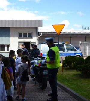 13. policjant WRD i policjanci OPP przy motocyklu, obok dzieci