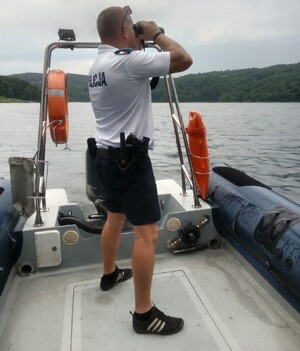 policjant na łodzi patrzy przez lornetkę — kopia