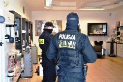 policjanci podczas kontroli salonu fryzjerskiego