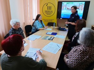 policjantka i uczestnicy warsztatów, w tle prezentacja multimedialna - fot. SUTW