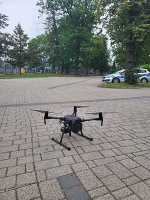 dron na parkingu, w tle radiowóz