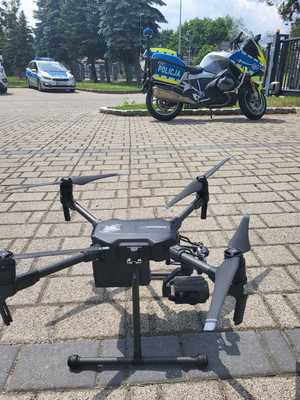 dron na parkingu, w tle służbowy motocykl
