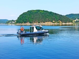 policyjna łódź na Jeziorze Rożnowskim, w tle Małpia Wyspa