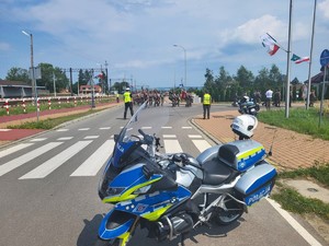 motocykl, służbowy, policjant drogówki, za nim uczestnicy uroczystości