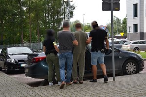 6. zatrzymany przy radiowozie prowadzony przez nieumundurowanych policjantów