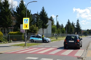 rejon szkoły, policjant kontroluje prędkość przejeżdżających pojazdów