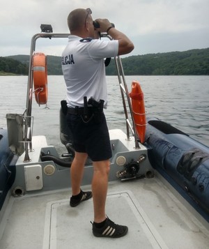 policjant na łodzi patrzy przez lornetkę — kopia