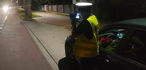 noc, policjant ruchu drogowego z laserowym miernikiem prędkości - fot. ilustracyjne