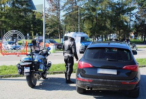 policjant podchodzi do pojazdu zatrzymanego do kontroli