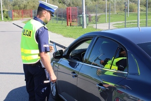 policjant rozmawia z kierowcą samochodu