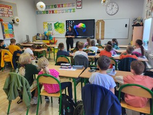 uczniowie w sali uczestniczą w spotkaniu z policjantką