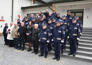 1. policjanci i uczestnicy uroczystości stoją na schodach prowadzących do budynku