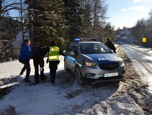 9. policjanci prowadzą zatrzymanego do radiowozu