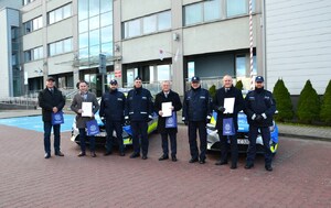 8. wspólne zdjęcie policjantów i samorządowców przy radiowozach