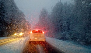 zimowe warunki na drodze, dwa jadące samochody, zaśnieżone drzewa