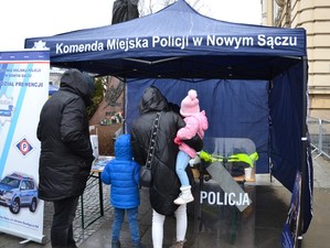 rodzina przy stoisku profilaktycznym policjantów