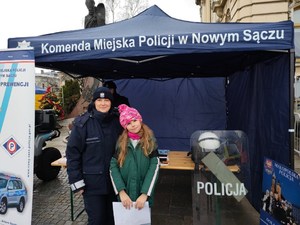 wspólne zdjęcie policjantki i dziewczynki w pobliżu stoiska profilaktycznego Policji