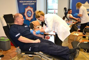 16. pracownica RCKiK przygotowuje umundurowanego policjanta do pobrania krwi